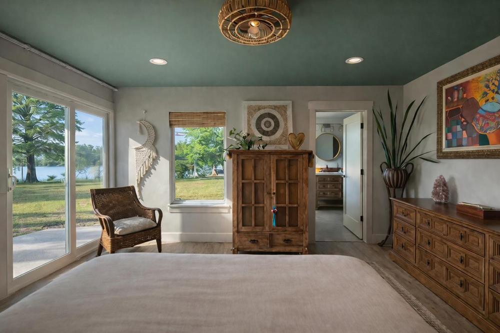 Primary suite with forest green ceiling and slider to the waterfront