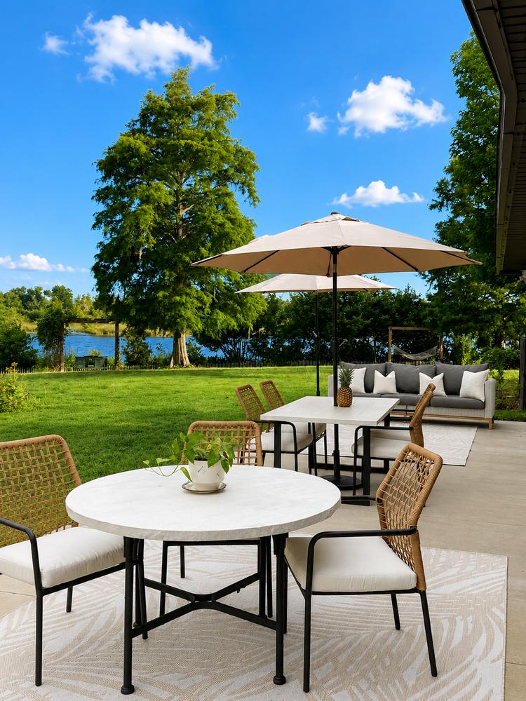 Dining table under umbrella with the lake framed by cypress
