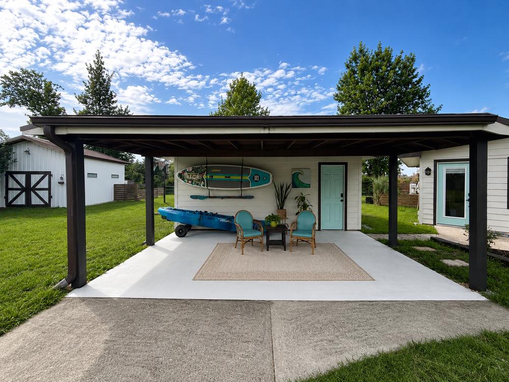 The man cave and covered garage, styled for lake life with kayak and paddleboard